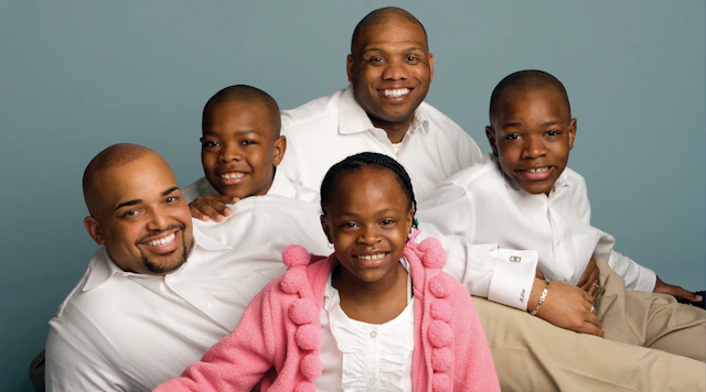 Family of five with two fathers posed in family portrait