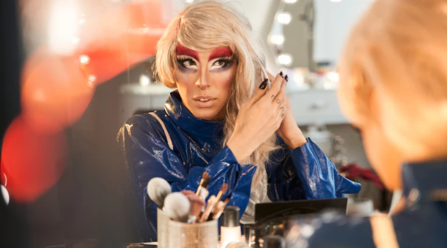 Drag performer looking in the mirror preparing to go on stage.