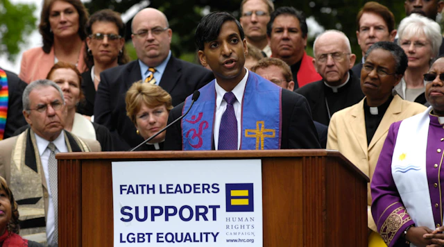 Group photo of faith leaders with one speaking behind a podium with a sign that reads "Faith leaders support LGBTQ Equality" with the HRC equality logo on it.