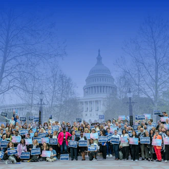 Large group shot of advocates in front of the capital with a blue gradient.