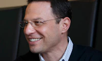 Man smiling off to the side with glasses and a sweater