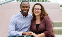 Inter-racial couple with arms around each other.